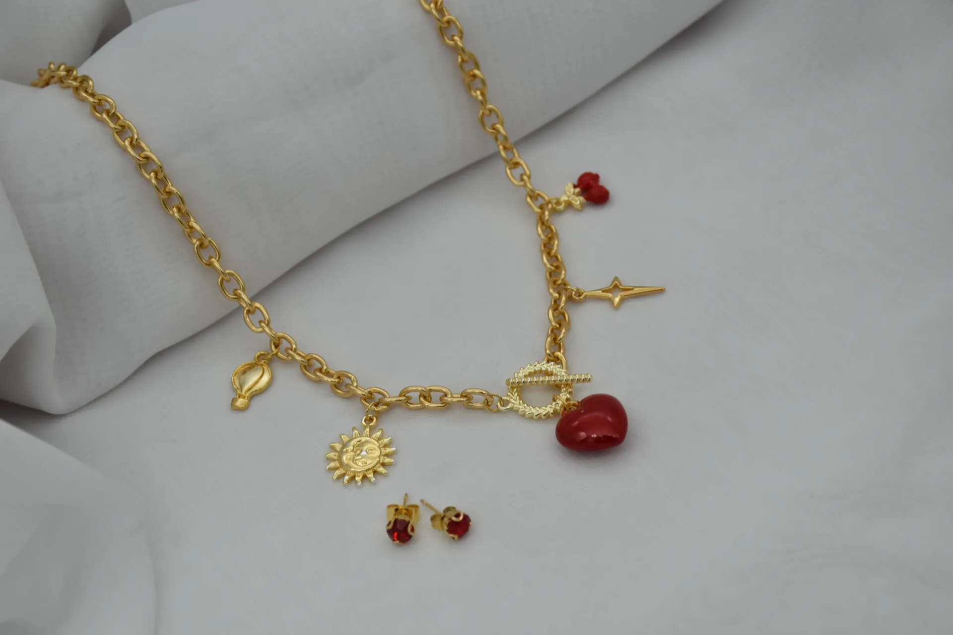 Collar dorado con dijes rojos